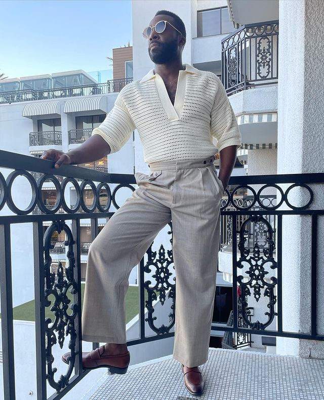 Tramell Tillman in a white woolen shirt and grey pants.